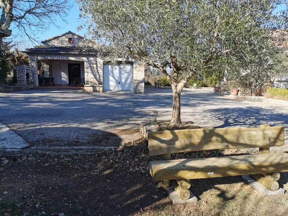 Gîte Nature courtyard with its olive tree and wooden bench